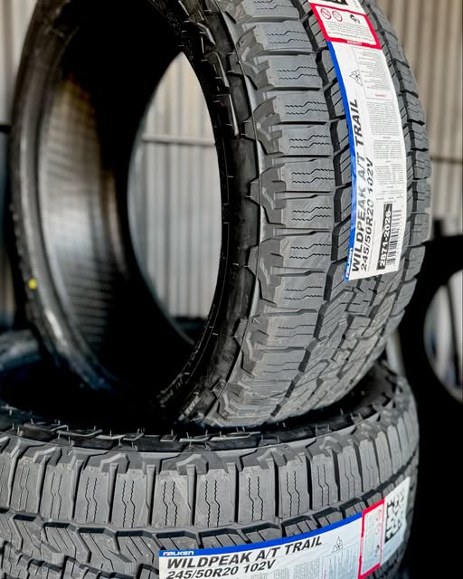 Two new all-terrain tires stacked, factory labels reading size 245/50R20 still attached.