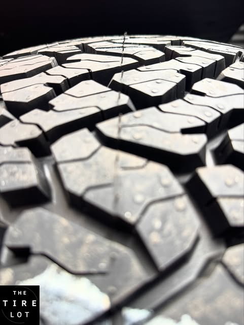 Extreme close-up of an all-terrain tire's tread blocks and sipes.